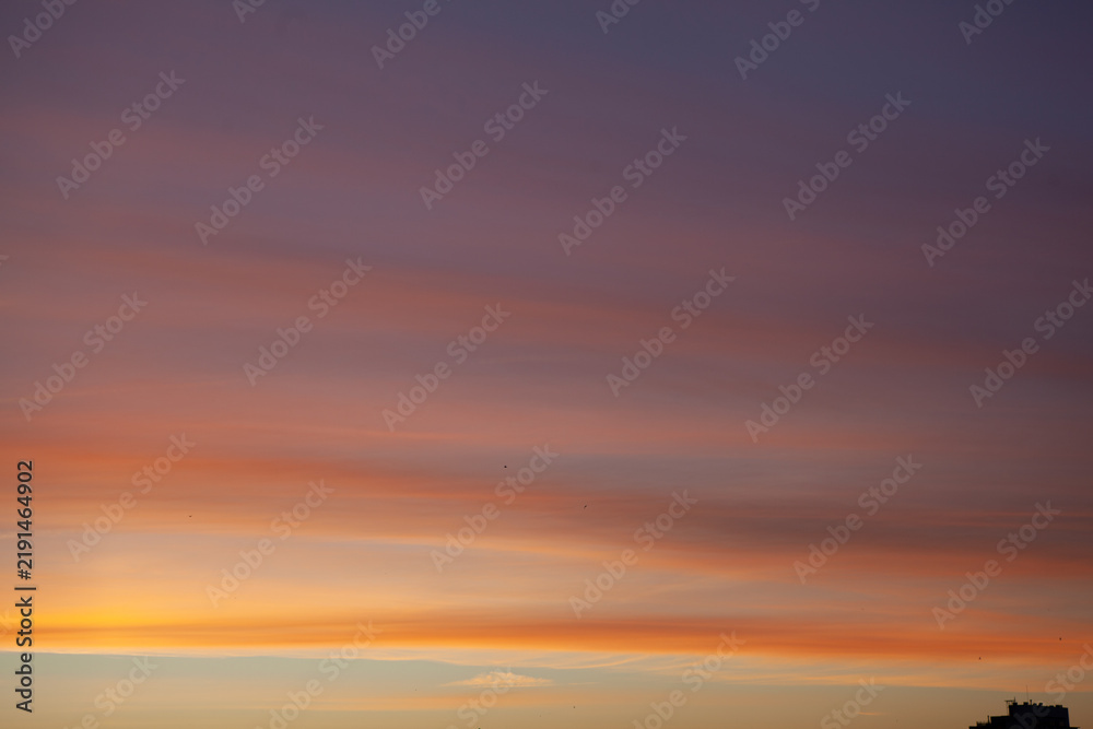 Fototapeta premium Sunset over the horizon with colorful clouds and light fading in the sky