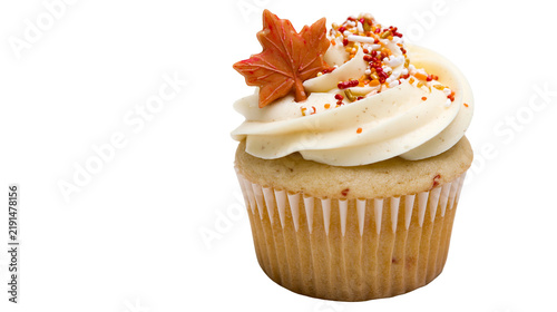 Vanilla cupcake with cream frosting and a decorative maple leaf sugar topper