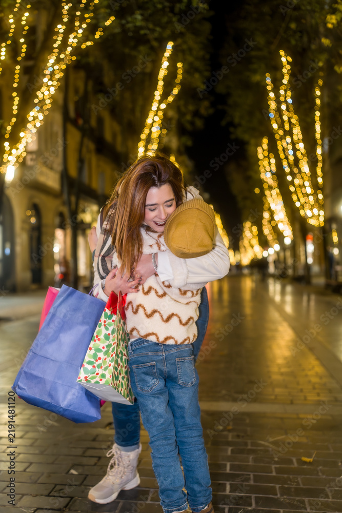 Obraz premium Mother and child hugging while christmas shopping