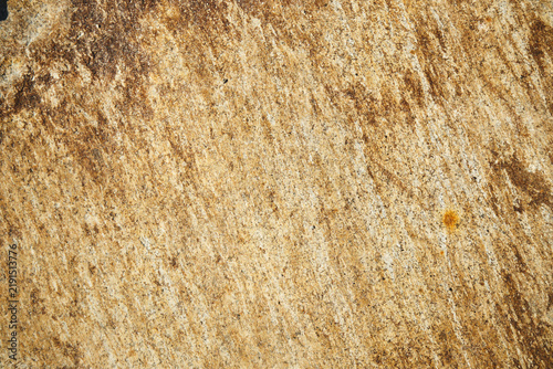 Obraz na płótnie Weathered golden brown rock face with natural diagonal mineral streaks