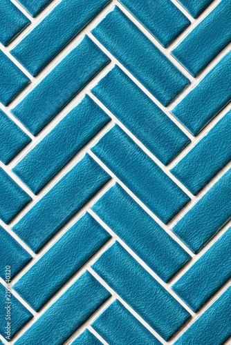 Teal herringbone tile pattern in interlocking geometry with white grout for interior design and home renovation marketing