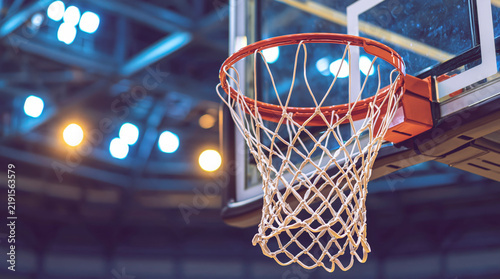 Basketball Hoop Net With Orange Rim And Backboard In A Brightly Lit Indoor Arena