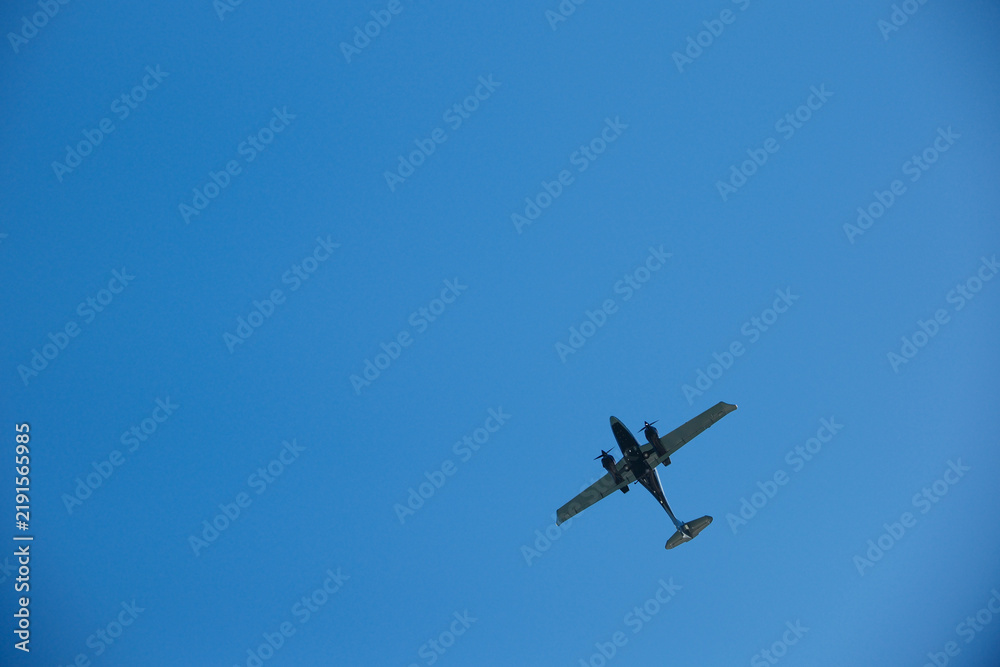 Fototapeta premium Twin-Engine Turboprop Airplane Flying in Clear Blue Sky