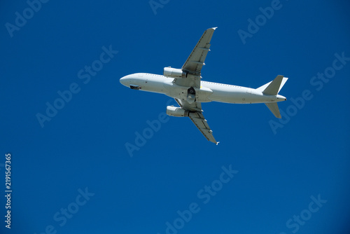 Konstfotografi White Passenger Airplane Ascending and Accelerating Against Blue Sky Minutes Aft
