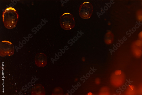 orange amber droplets bubbles dark black background macro close up abstract liquid texture bokeh light night concept of abstract, background, design