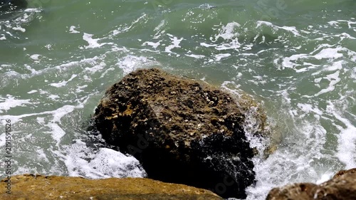 video al rallentatore di acqua di mare che si infrange sugli scogli lungo la costa di giorno