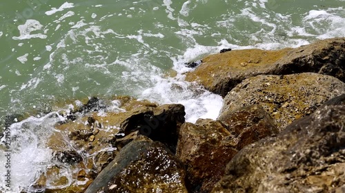 video al rallentatore di acqua di mare che si infrange sugli scogli lungo la costa di giorno