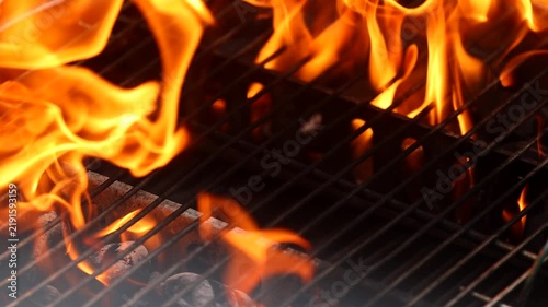 video dettagliato di fiamme che si muovono e di bronze che ardono in una griglia durante la preparazione di un barbecue
