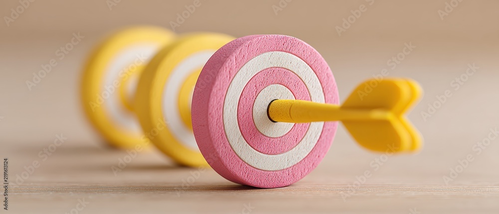 Obraz premium A detailed view of vibrant dartboard targets featuring yellow darts directed at the center representing accuracy determination and success in a clean and simple environment