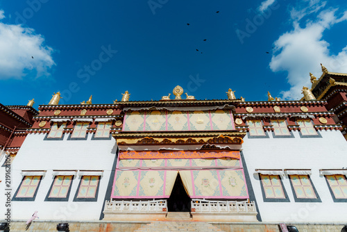 Bild auf Leinwand Golden dharma wheel atop Songzanlin Monastery main entrance facade