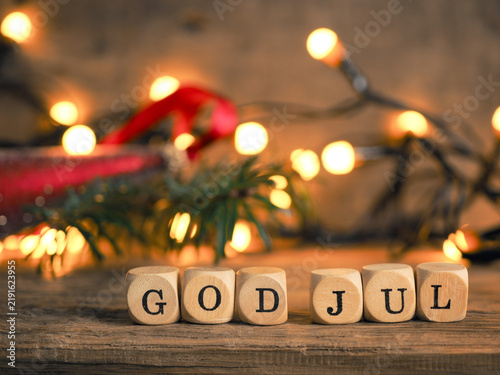 Small wooden blocks with God Jul and white Christmas lantern, rustic wooden background