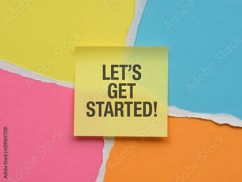 Lets Get Started encouraging phrase on yellow sticky note displayed on torn vibrant colored papers