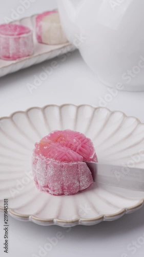 Homemade pink and white snow skin mooncakes with floral mold patterns, a no-bake Mid-Autumn Festival treat with yellow custard cream