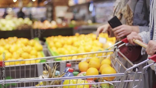 People shopping for groceries with cart and payment card in supermarket