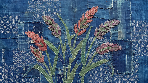 Traditional japanese sashiko embroidery art featuring delicate hand stitched wheat stalks on textured indigo blue fabric