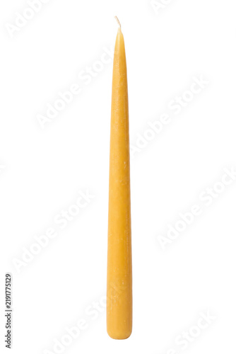 Fotografie Single tall yellow taper candle with a pointed top and visible wick stands uprig