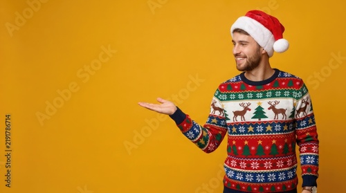 Happy smiling man in a santa hat and a colorful christmas sweater presenting with an open hand gesture