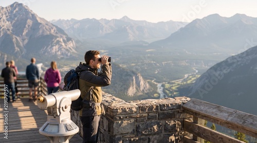 Tourist Using Binoculars at Scenic Mountain Overlook Viewing Platform