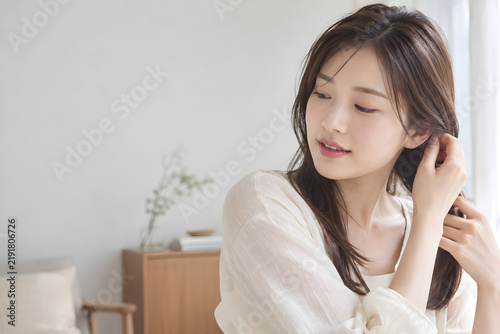 髪を耳にかける自然な仕草と透明感のある肌が映える女性 柔らかな光とナチュラルメイクを生かした美容広告向けコピースペース