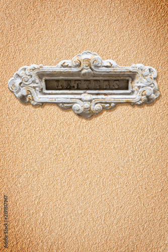 Obraz na płótnie Old decorative postal mailbox with letters text against a plaster wall - image w