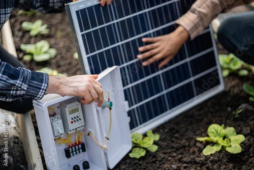 Close-up of hands connecting a solar panel to its open control box