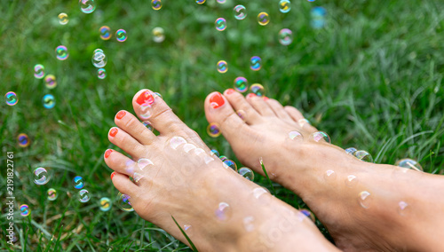 Canvastavla Bare feet with red toenail polish on grass
