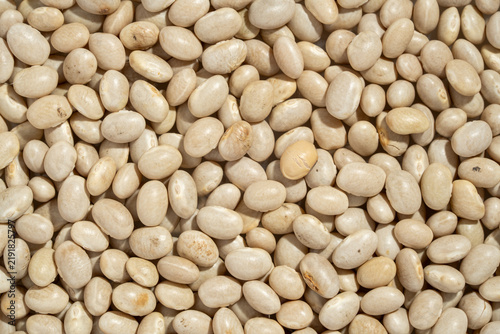Raw organic white navy beans texture background.