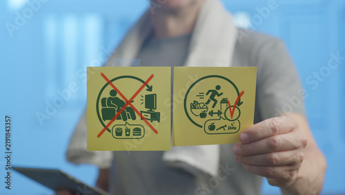 Foto Person is holding two yellow square signs, one with a red cross over symbols of