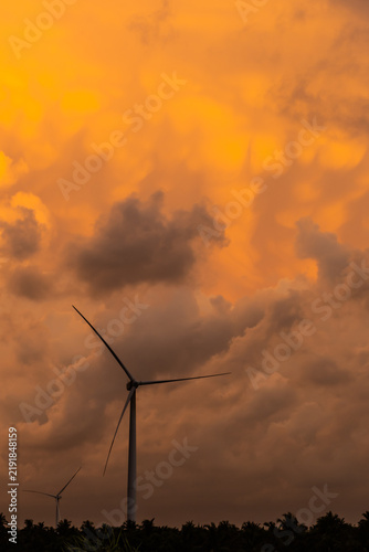 Wind turbines stand beneath glowing mammatus clouds at sunset in Kalpitiya, Sri Lanka, highlighting renewable energy against an extraordinary tropical storm sky.