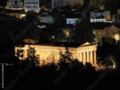 Bild auf Leinwand Classical Greek Hephaestus temple lit up at night with residential buildings vis