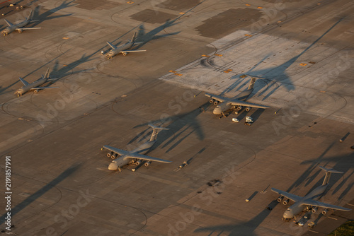 Aerial view of military transport aircraft parked on the tarmac at Travis Air Force Base during golden hour in Fairfield, California, United States.