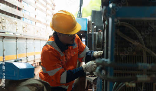Fotografía Tractor mechanic inspecting and repairing engine components while performing agricultural machinery maintenance, ensuring reliable equipment operation and efficient farming performance
