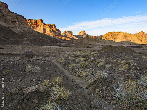 Canvastavla A narrow footpath winding through the arid scrubland towards distant mountains o