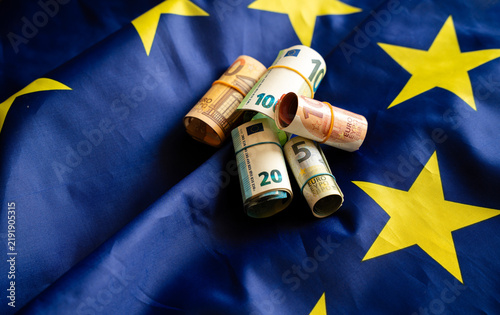 Euro banknotes cash money on European Union flag background	

