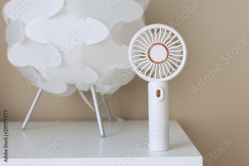 Mini fan and decor on white table, closeup