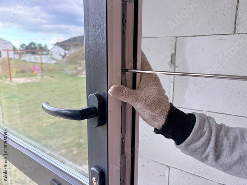 Window frame adjustment. Worker use a screwdriver to adjust the new windows. Manual window frame adjustment