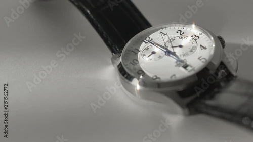Timelapse Of Moving Clock Hands On Classic Wristwatch In Sunlight On White Background. Time Goes By Watch Time Lapse. Copy Space. Movement of clock hands on a classic wristwatch. The close-up view