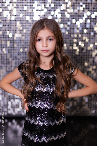 Portrait of Young Girl in Sequined Dress with Glitter Bokeh Background