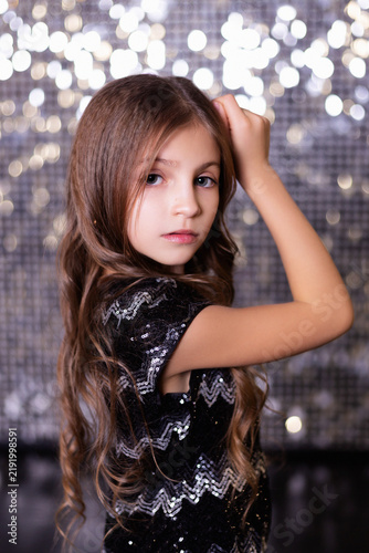 Portrait of Young Girl in Sequined Dress with Glitter Bokeh Background