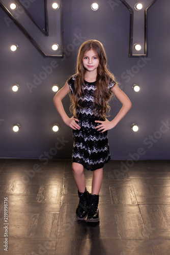 Girl in Sequined Dress Posing Against Illuminated NY Marquee Background