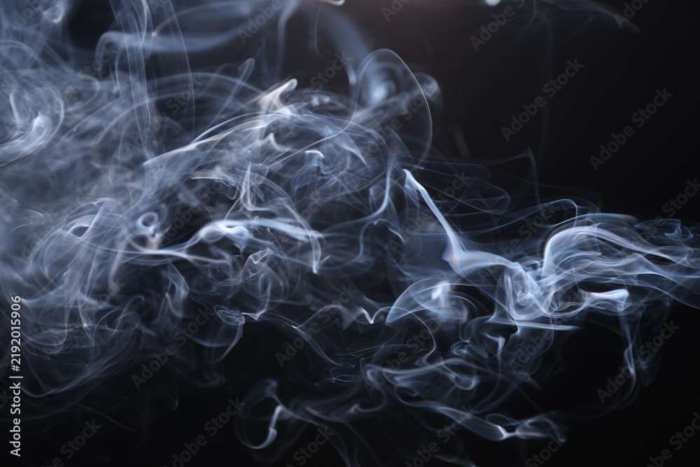 Obraz premium Beautiful smoke in light on black background