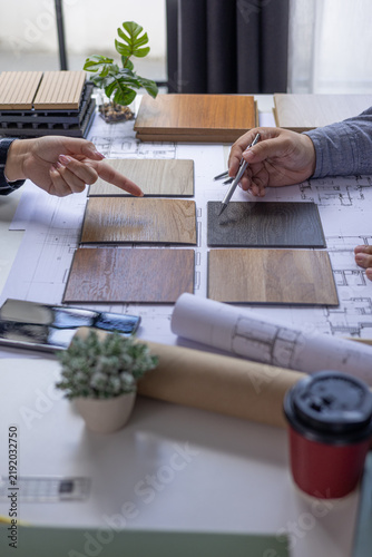 Bild auf Leinwand Architect and Interior Designer Collaborating on Floor Plans with Wood Samples