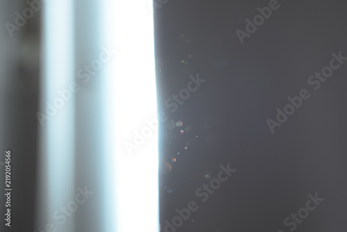 Dust particles against the backdrop of a bright beam of light in the room
