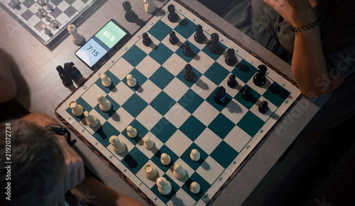 Картината върху платно Chess tournament under time pressure, players compete over board with digital clock, strategy, concentration, decision making and intellectual sport