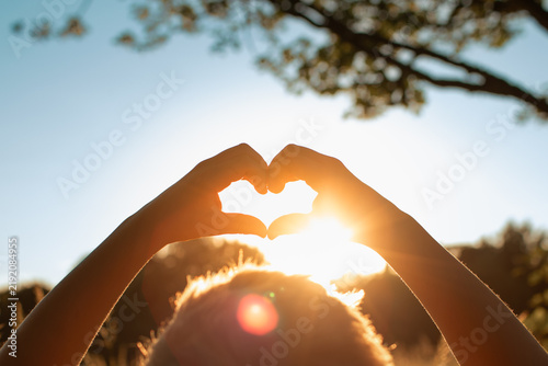 Heart Shape Hands Framing Sun at Sunset, Love, Faith, Gratitude and Hope Concept
