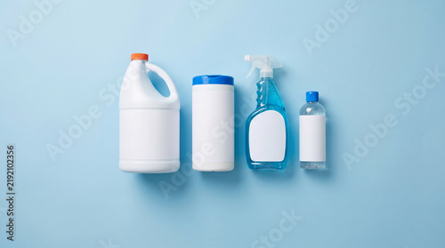 Assortment of cleaning products arranged on a plain blue background