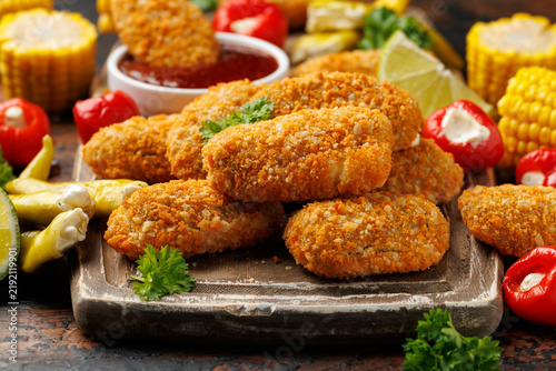 Crispy baked cream cheese stuffed jalapeno poppers with lime wedges and sweet chili sauce