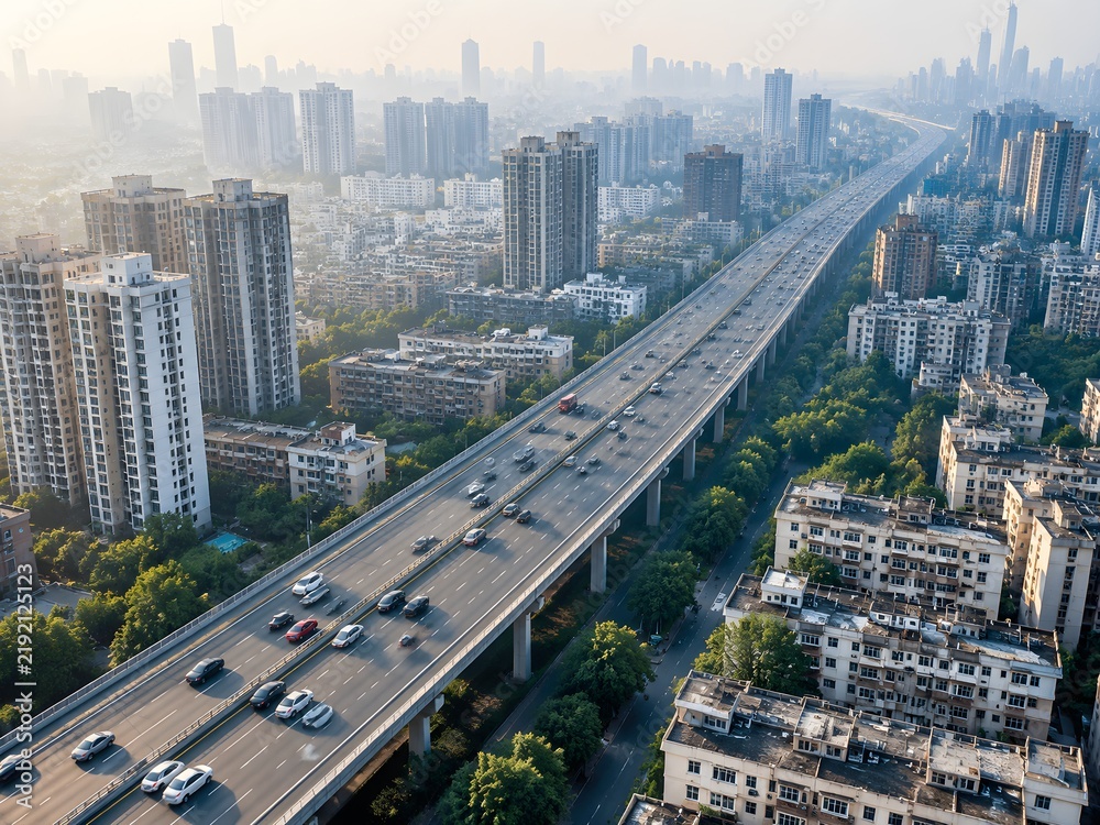 Fototapeta premium Elevated freeway filled with anonymous cars among dense city blocks in morning haze