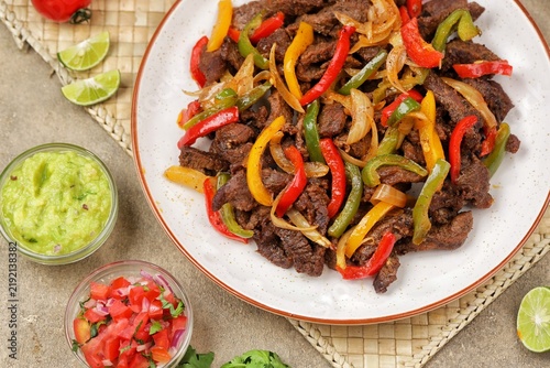 Beef fajitas made with tender strips of seasoned beef, colorful bell peppers, and onions, served hot with soft flour tortillas. Tex-Mex food