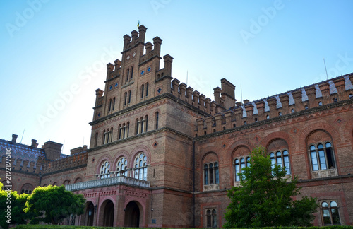Canvastavla The ornate brick facade and tiled roof of Chernivtsi University under warm sunli